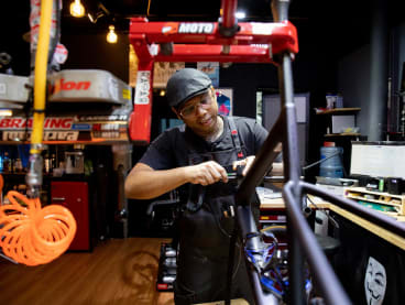 Bicycle mechanic Alfred Goh working on a bicycle in his store, Inkedmechanic.