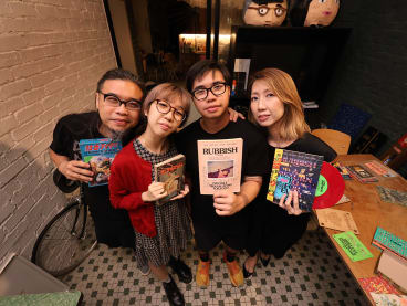 From left: Mr Pann Lim with his daughter Aira, son Renn, and wife Claire. The family is holding up different versions of the Rubbish Famzines that they have created over the years.