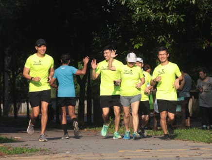 Mr Adrian Phoon (far left) and some members of The Morning Greeters greeting a runner while running at Woodlands Waterfront Park on June 9, 2024. 