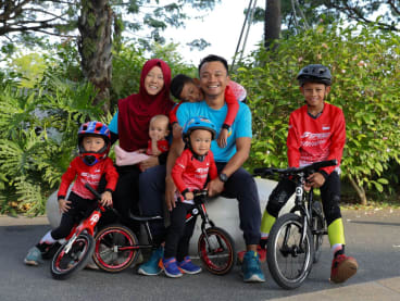 Mr Muhammad Hafiz Abdul Khalid (centre) with his wife Siti Liyana Mohamad Yusof and their children at PAssion Wave@Marina Bay on July 22, 2024. The couple co-founded Balance Bike SG in 2023. 
